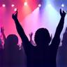 A jubilant crowd at a live music event, hands raised in excitement.